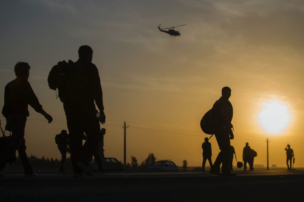 soldiers outlines with packed bags by the sunset