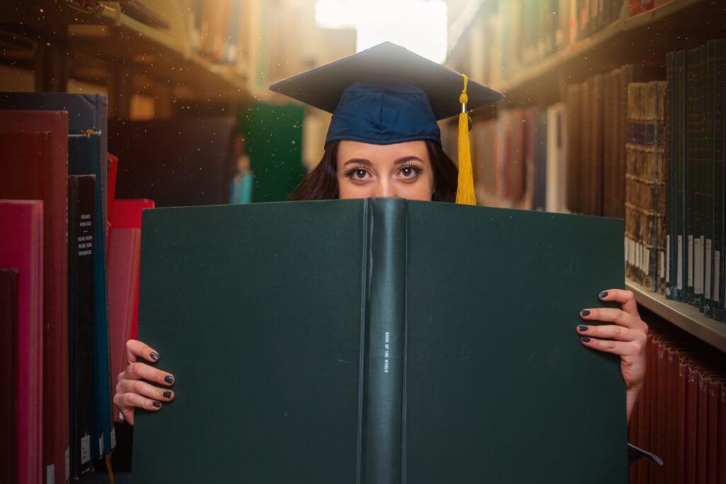 female college graduate holding a book